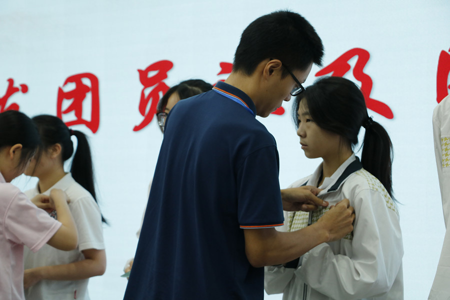 优秀团员为新团员佩戴团徽.JPG